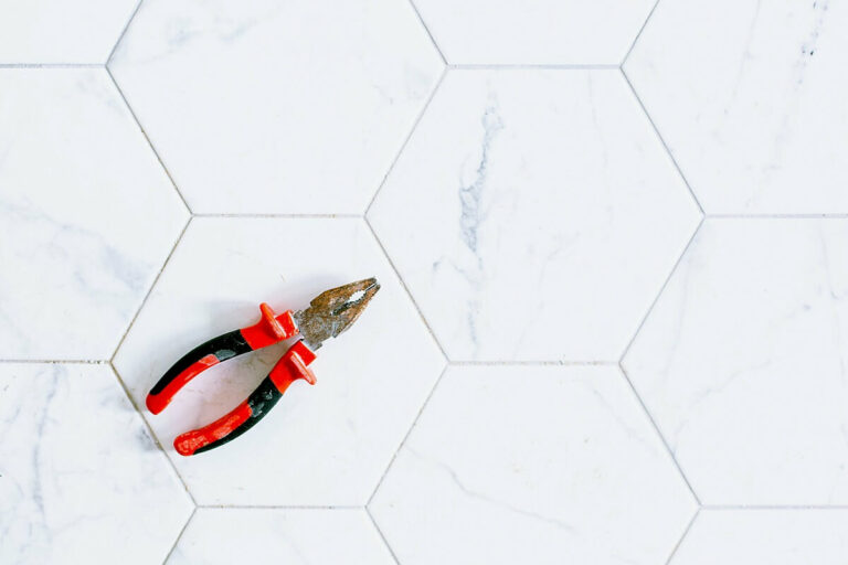 A pair of pliers on some hexagonal marble tiles