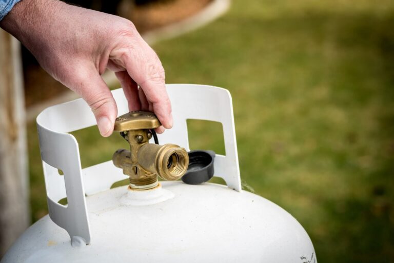 A person adjusting a backyard propane tank