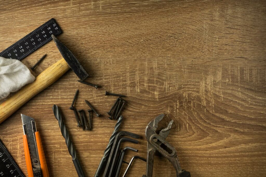 Screws and other tools on a wooden surface